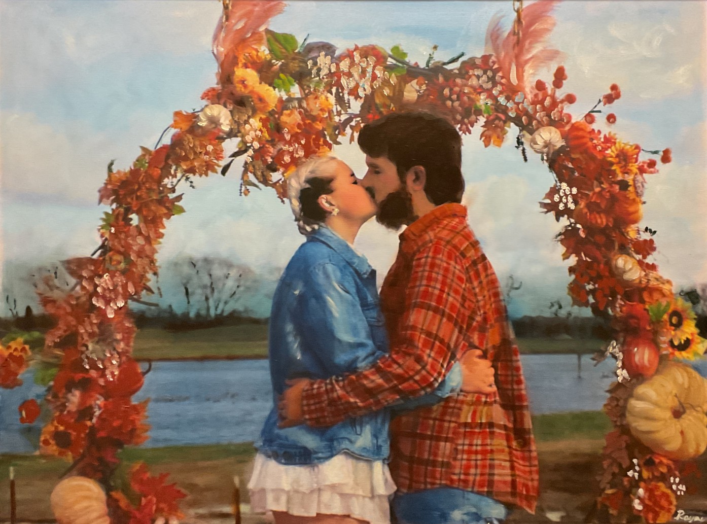 Wedding portrait of a couple beneath an autumn floral arch